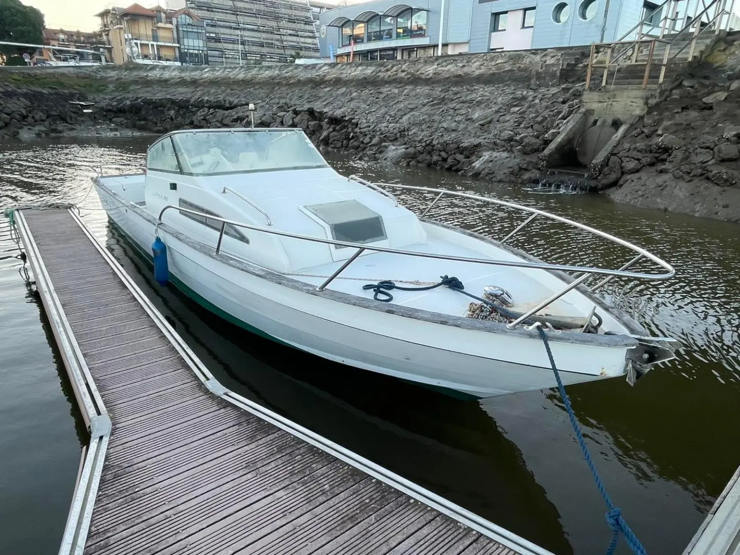 Guy Couach Pyla 800 — Bateau à moteur blanc amarré à un ponton, vu de trois quarts avant.
