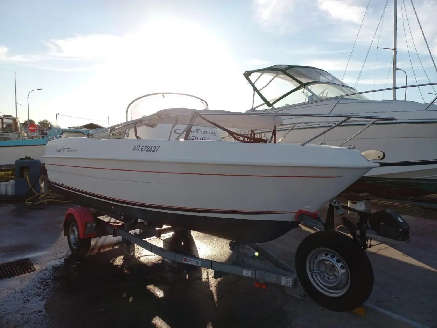 B2 Marine 552 — Bateau à moteur blanc sur remorque, photographié de trois quarts dans un port.