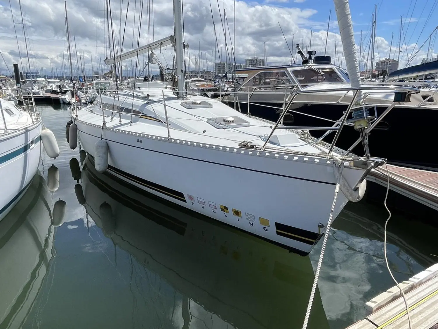 Kirie Feeling 1040 — Voilier blanc amarré dans une marina, photographié de trois quarts avant.