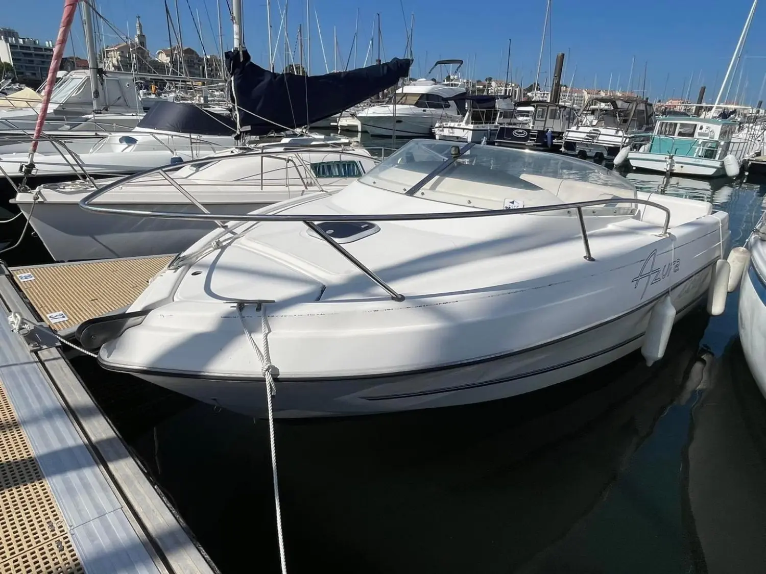 Kelt Azura 600 — Bateau à moteur blanc amarré dans une marina, vu de trois quarts avant.
