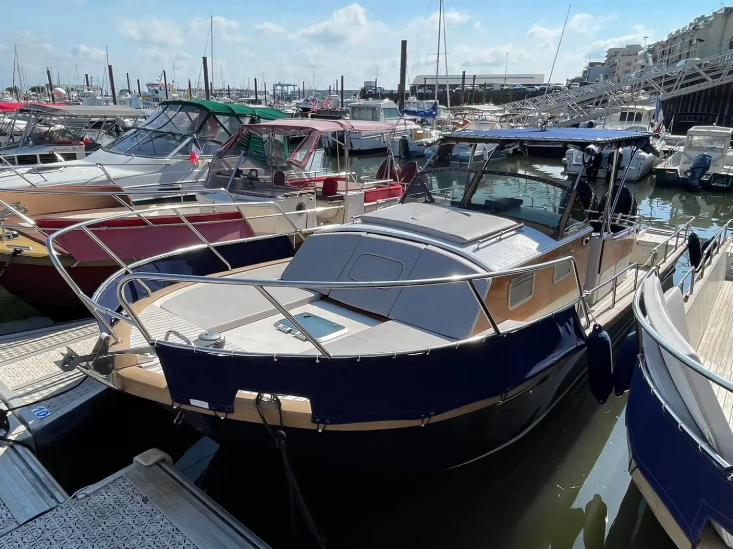 Beacher 840 — Bateau à moteur amarré dans un port de plaisance, vu de trois quarts avant.