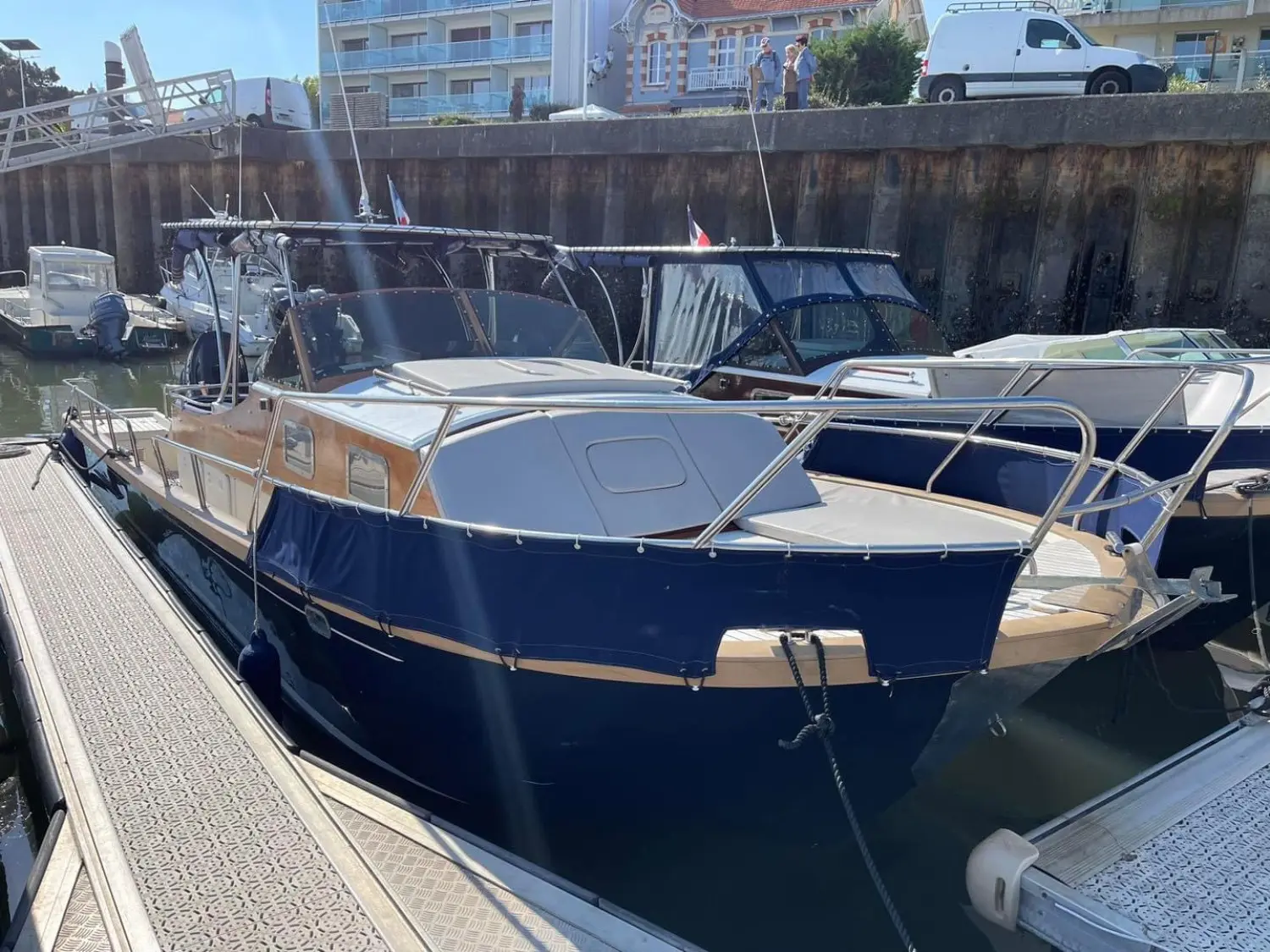 Beacher 840 — Bateau à moteur bleu amarré dans un port, vu de trois quarts avant.
