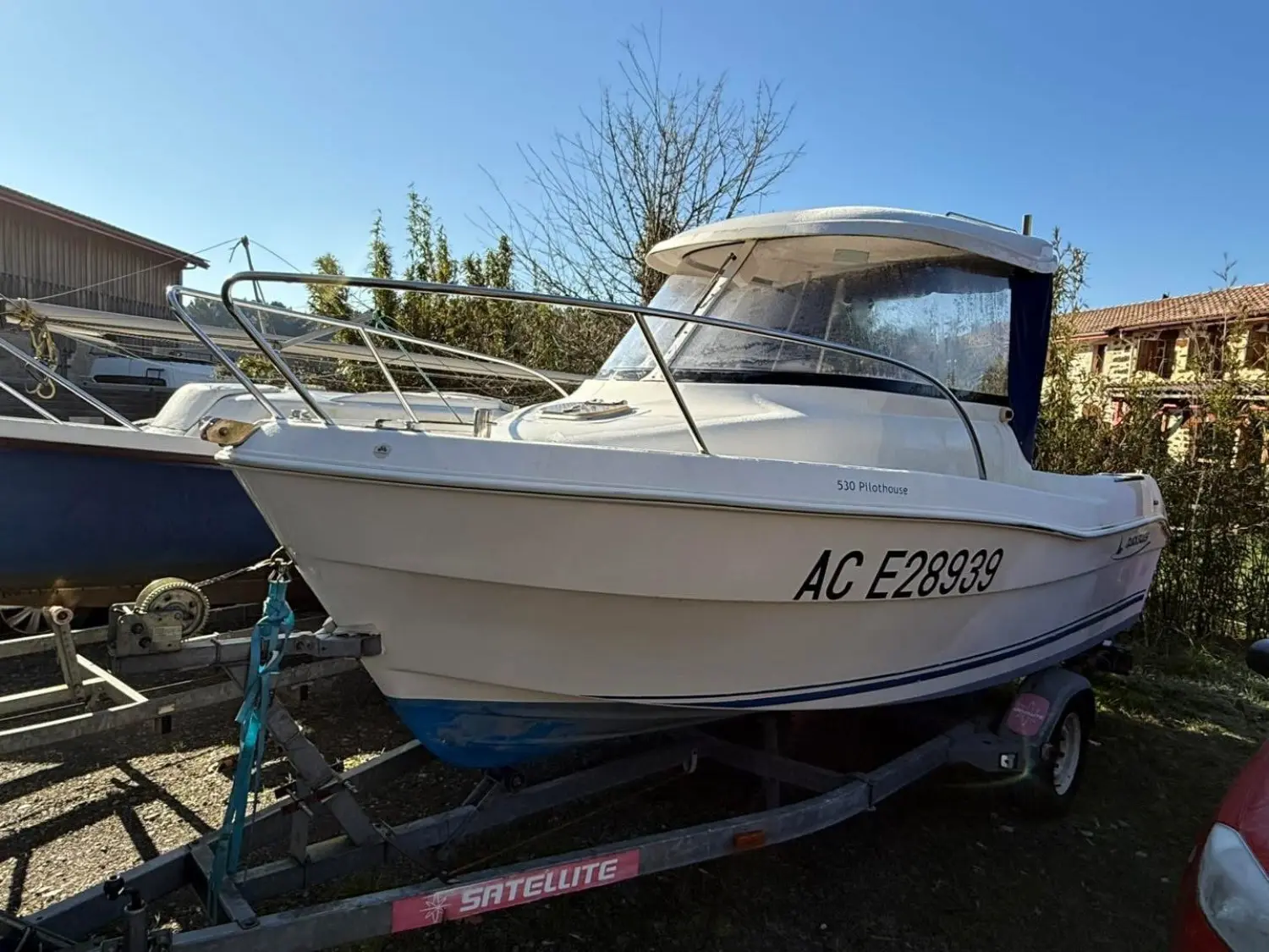 Quicksilver 530 — Bateau à cabine blanche photographié sur sa remorque, vu de trois quarts avant.