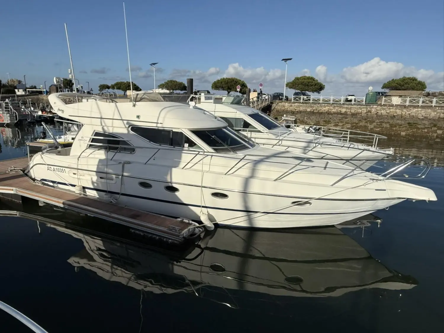 Cranchi Atlantique 38 — Bateau à moteur blanc amarré dans un port, vu de trois quarts.