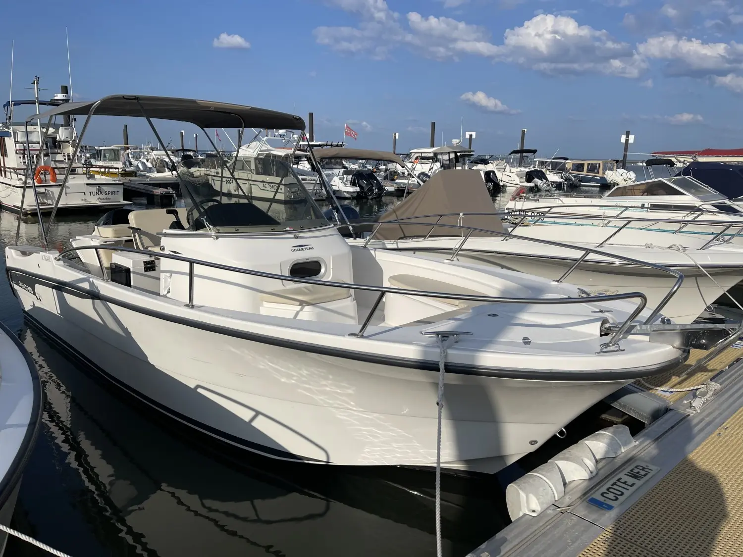 Ocqueteau Abaco 800 Open CC — Bateau à moteur blanc amarré dans une marina, vu de trois quarts avant.
