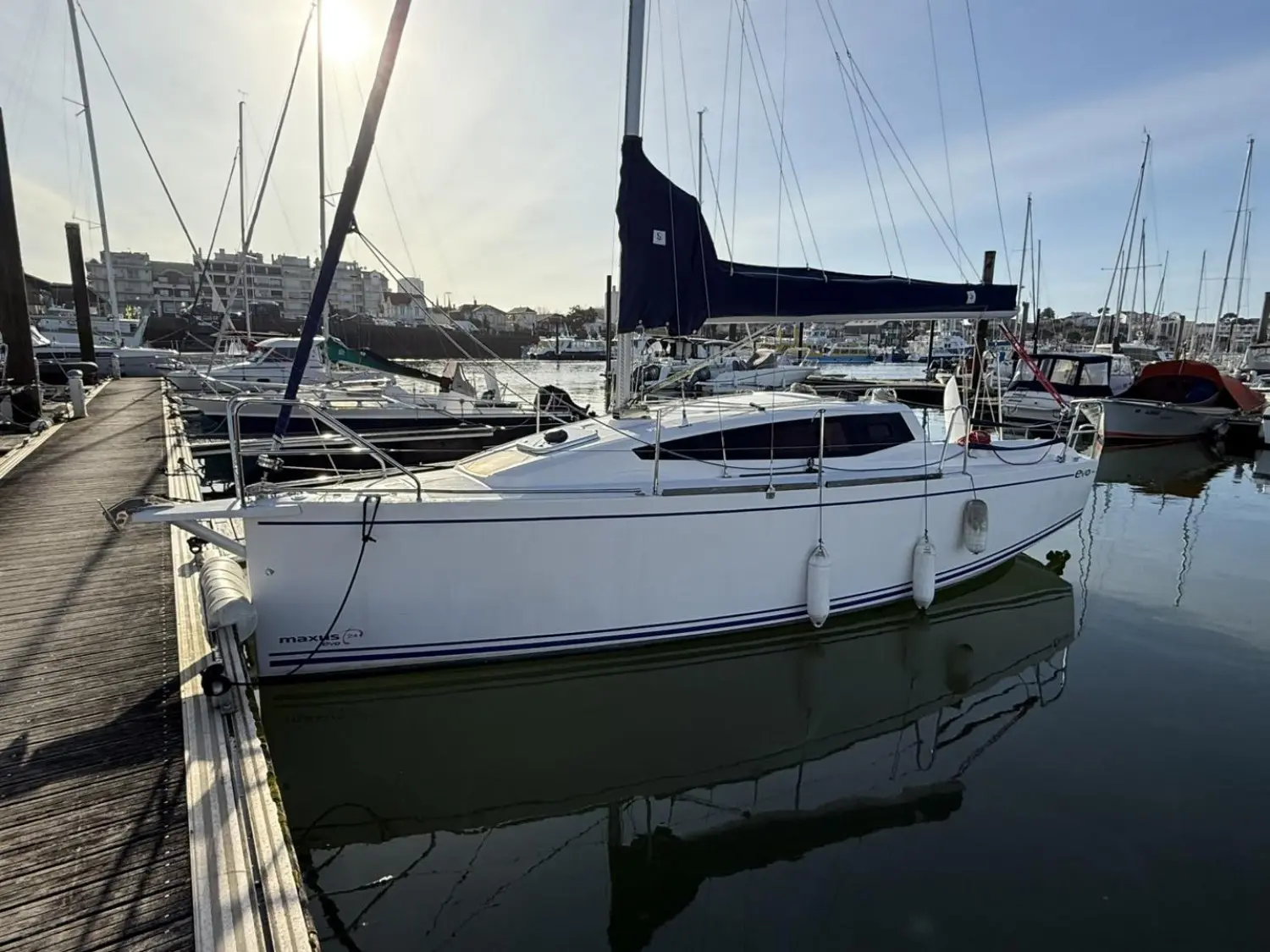 Maxus 24 — Voilier blanc amarré dans un port, photographié de profil trois quarts.