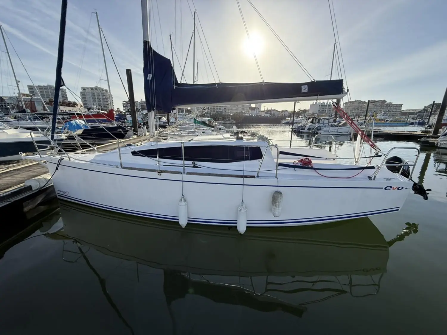 Maxus 24 — Voilier blanc amarré, vu de profil dans un port de plaisance.