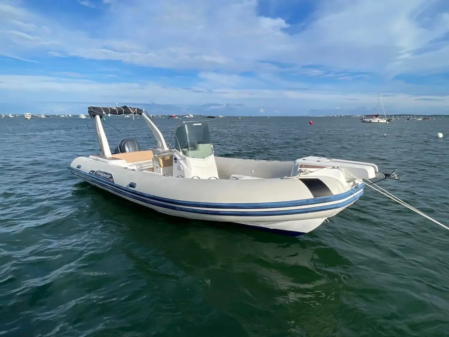 Capelli Tempest 770 — Bateau pneumatique blanc vu de trois quarts sur l’eau, avec console centrale.