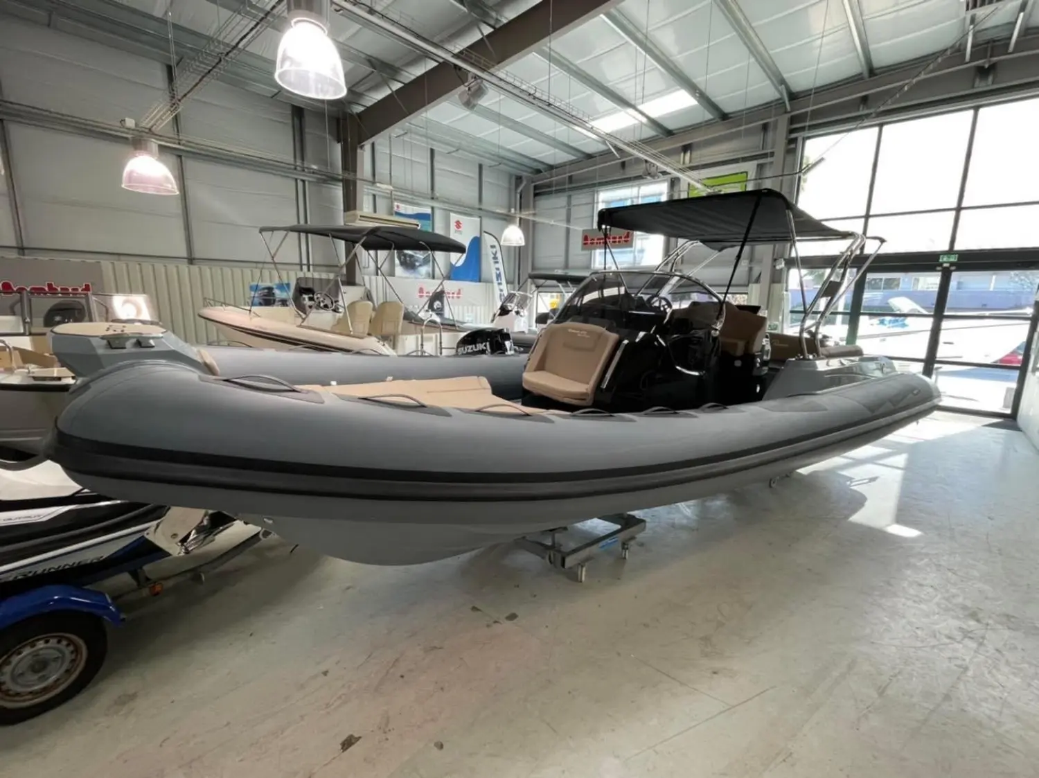 Ranieri Cayman 27 Sport Touring Trofeo — Semi-rigide gris exposé sur remorque dans un showroom nautique.