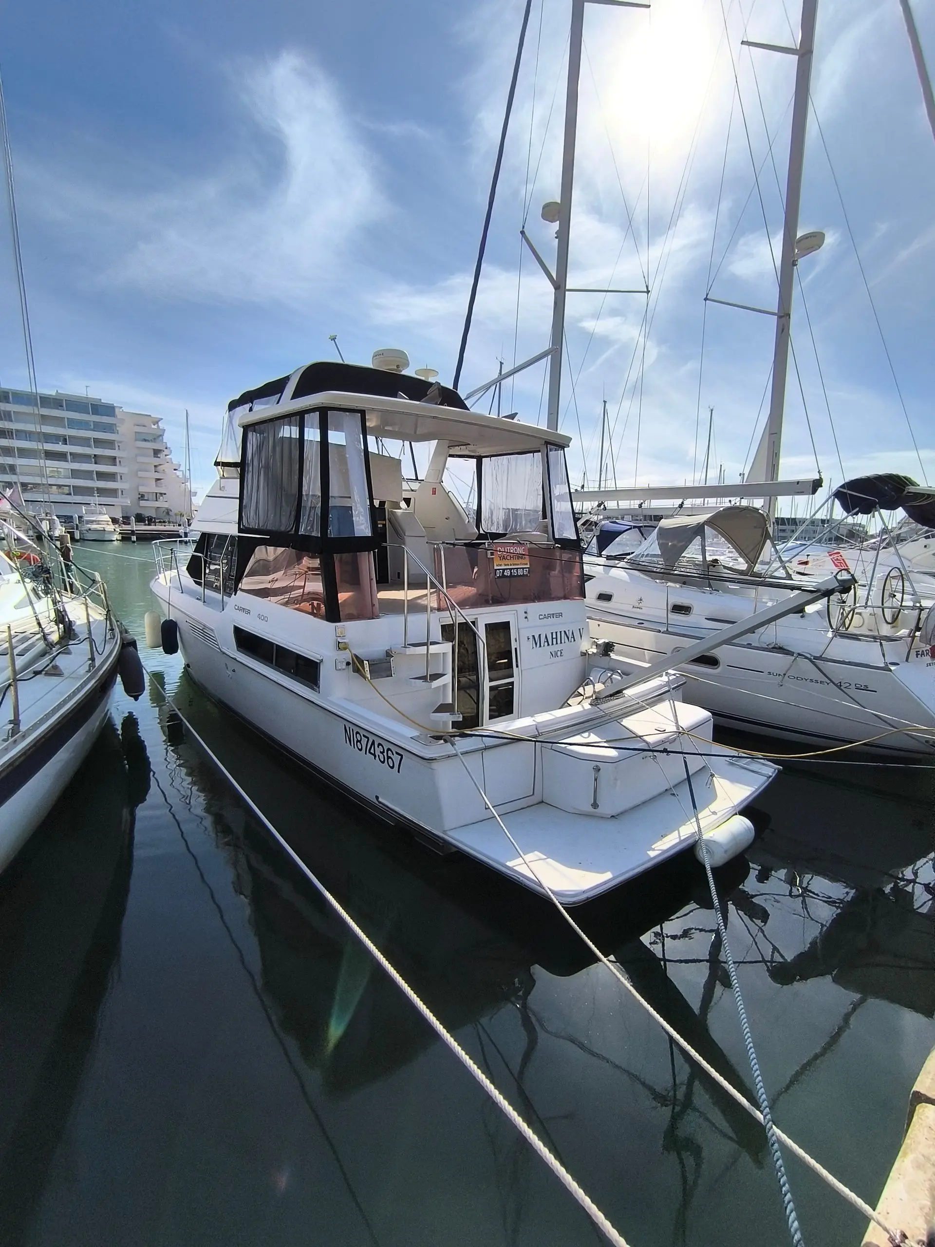 Carver 400 — Bateau à moteur blanc amarré dans une marina, vu de trois quarts arrière.