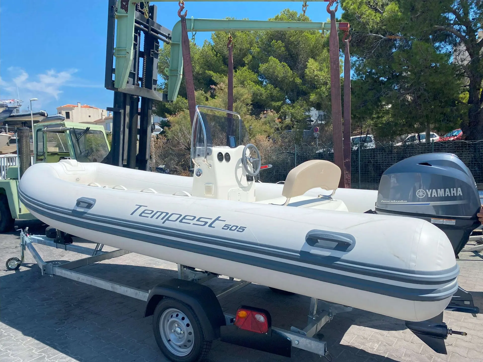 Capelli Tempest 505 — Bateau pneumatique blanc présenté sur remorque, avec console centrale et moteur hors-bord.