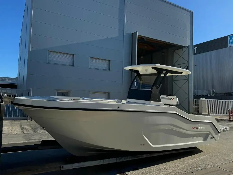 Seagame 230 X — Bateau à console centrale photographié sur une remorque devant un hangar.