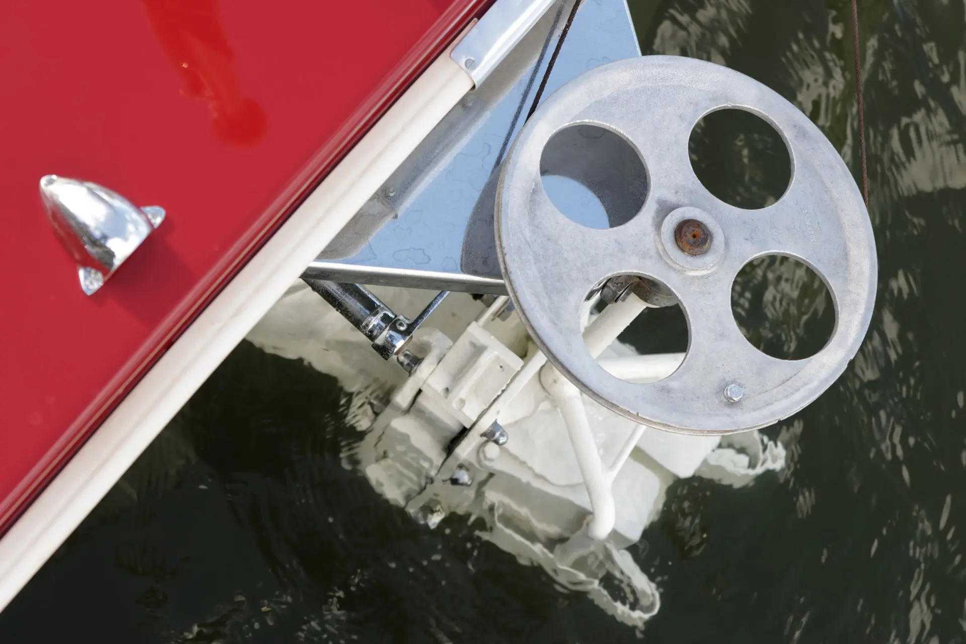 Dowty Turbocraft — Vue rapprochée d’un mécanisme métallique sur le côté d’un bateau rouge.