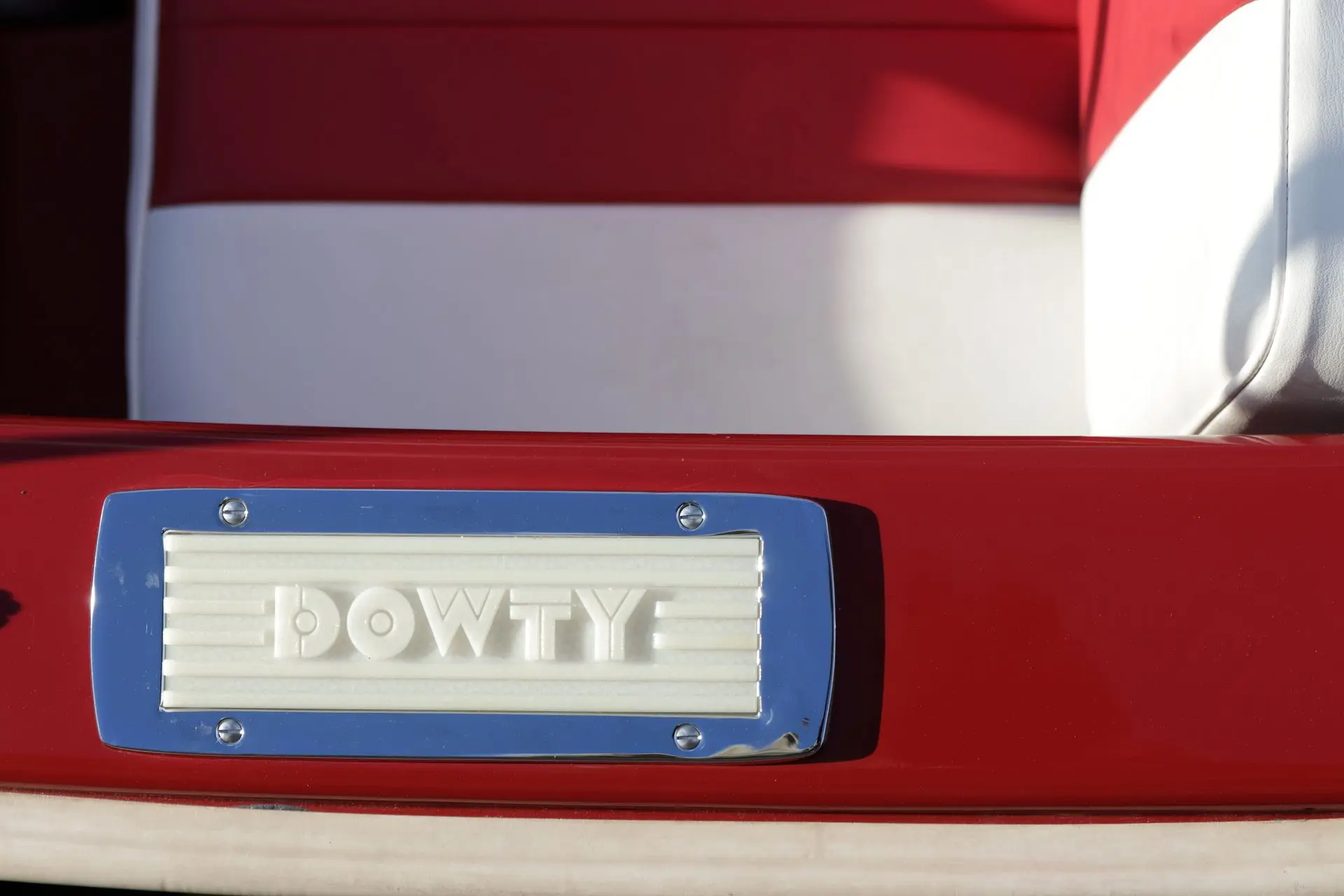 Dowty Turbocraft — Plaque portant l'inscription « DOWTY » sur une surface rouge et blanche du bateau.
