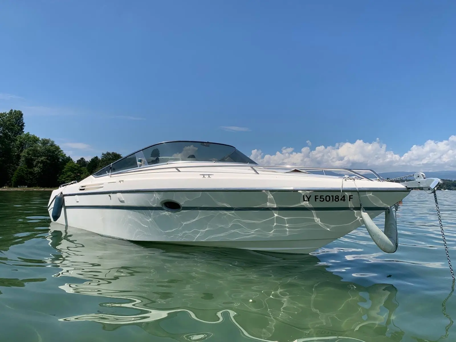 Cranchi Clipper 760 — Bateau à moteur blanc vu de profil, au mouillage sur un lac.