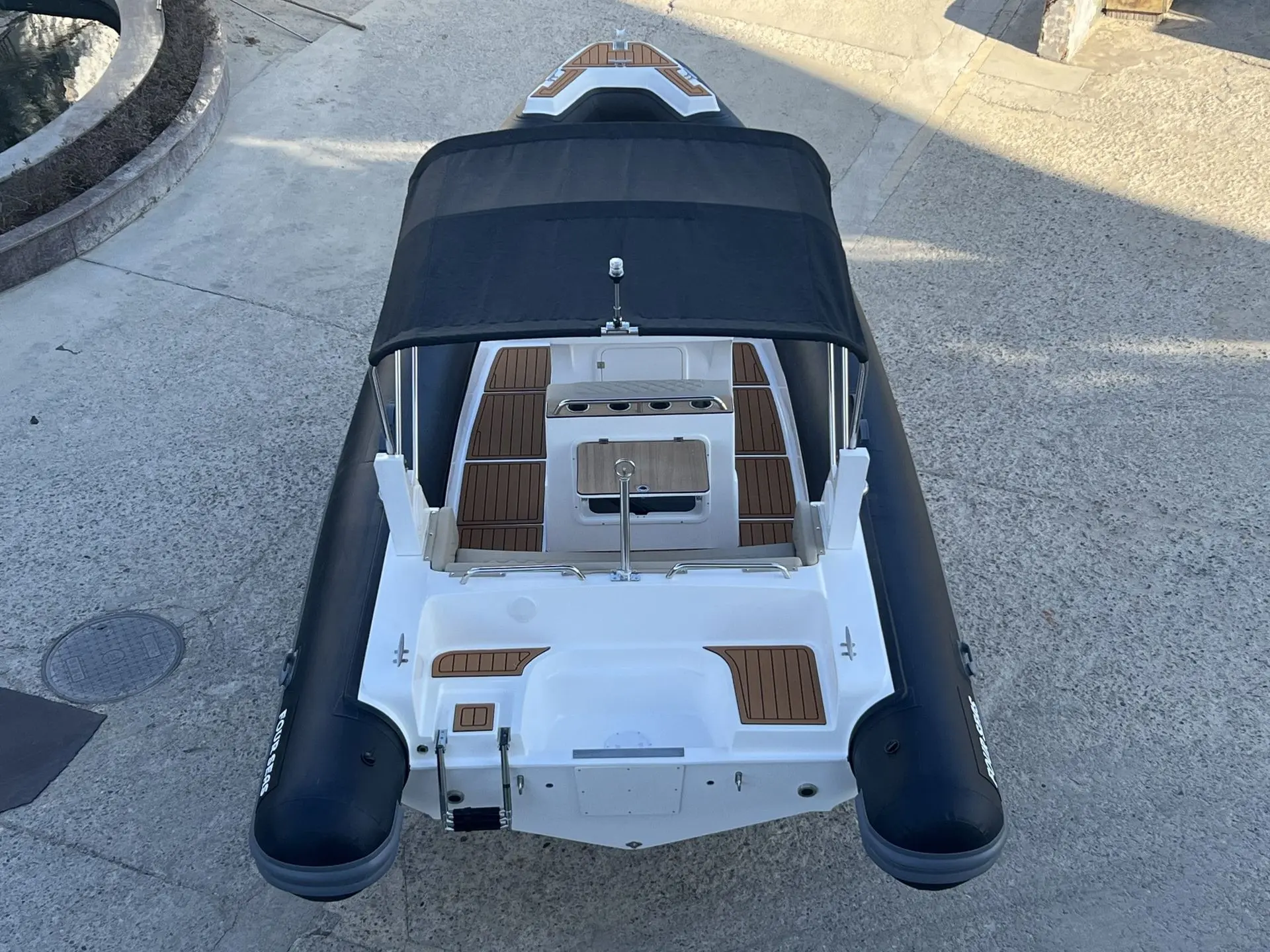 Four Seas F 680 — Vue plongeante d’un bateau semi-rigide blanc et noir avec taud et pont imitation teck.