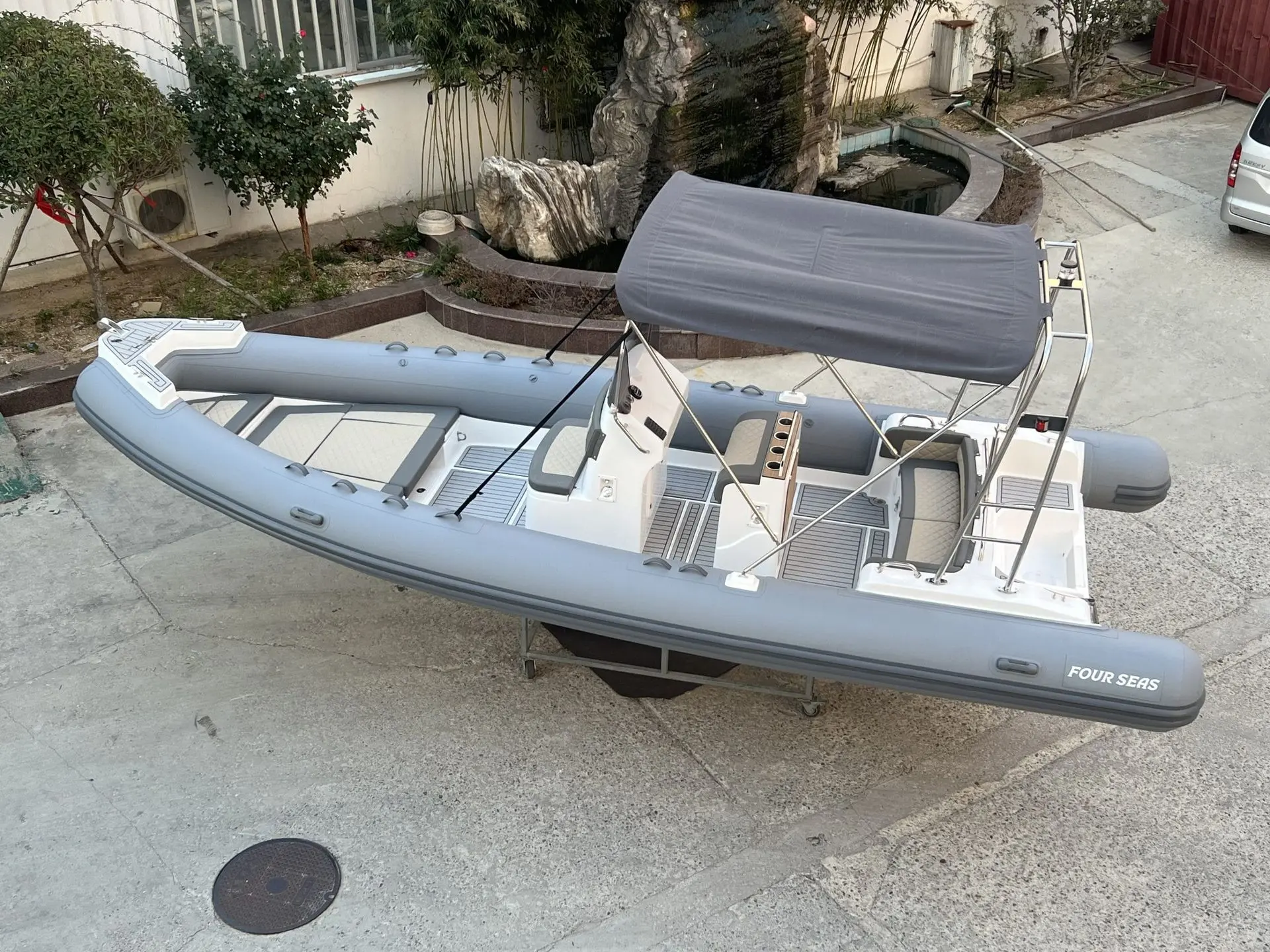 Four Seas F 750 — Bateau pneumatique gris vu de trois quarts, avec console centrale et taud.