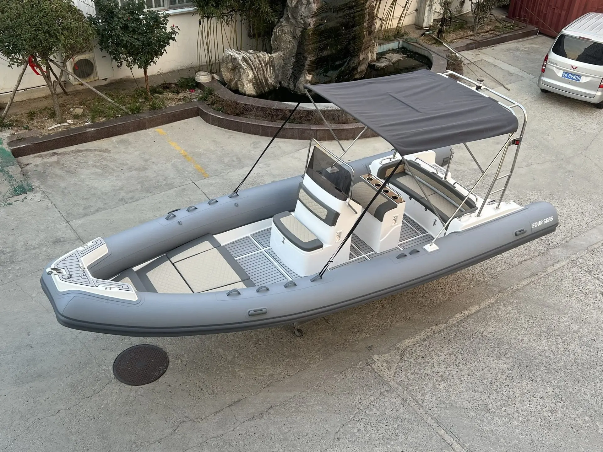 Four Seas F 750 — Bateau pneumatique gris avec console centrale, banquettes et taud de soleil.