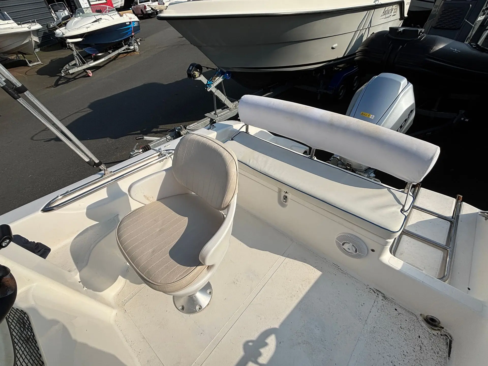 Janmor 531 Cabine — Vue partielle du cockpit arrière, avec siège de pilotage, banquette et moteur hors-bord.
