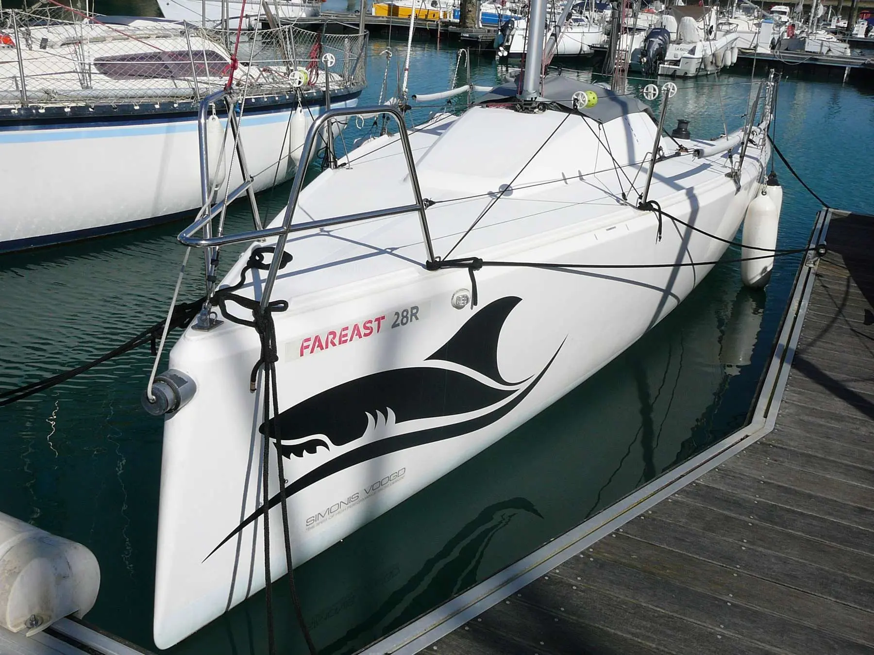 Fareast 28 R — Voilier blanc amarré dans une marina, vu de trois quarts avant.