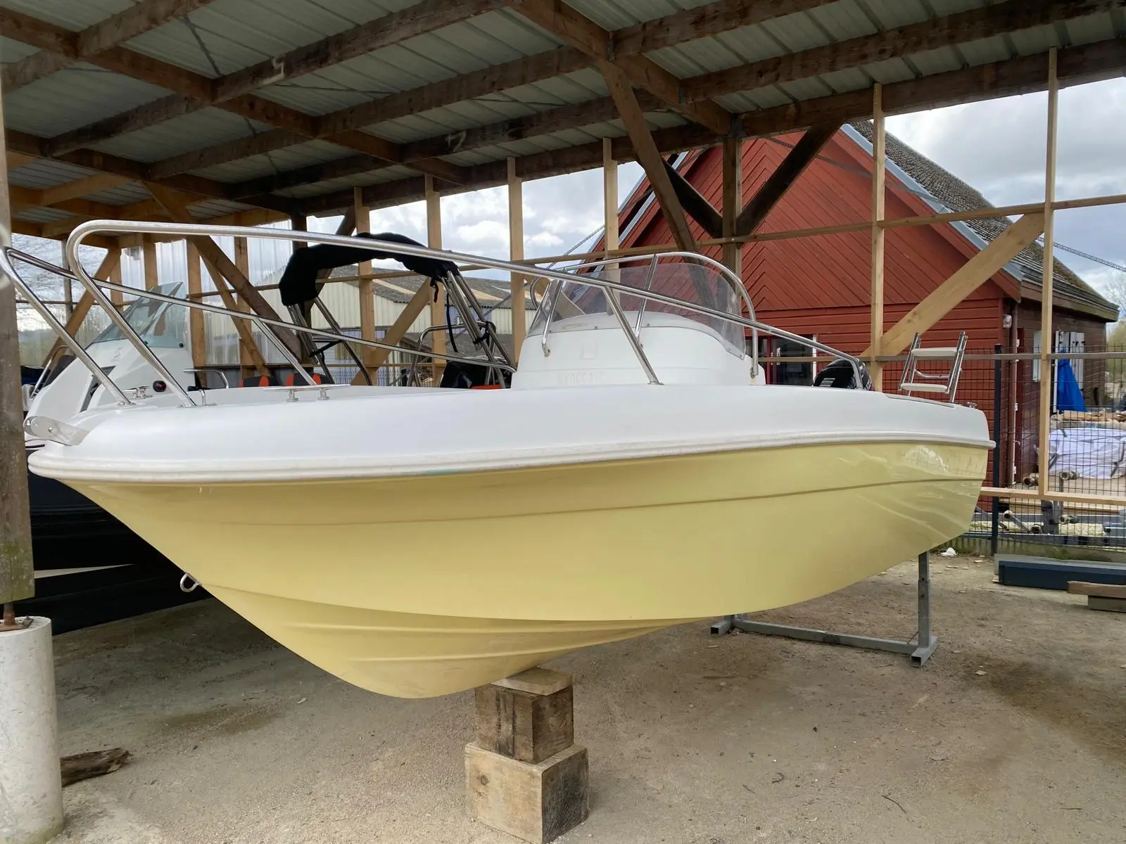 Jeanneau Cap Camarat 515 — Bateau à moteur blanc présenté sur bers sous un abri couvert.