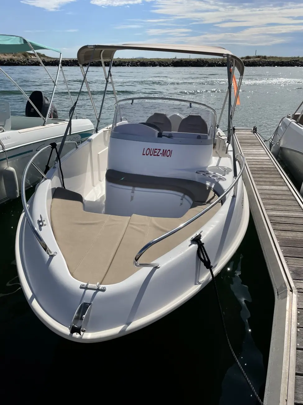 B2 Marine 552 — Bateau à moteur amarré, vu depuis l’avant, avec taud et pare-brise.