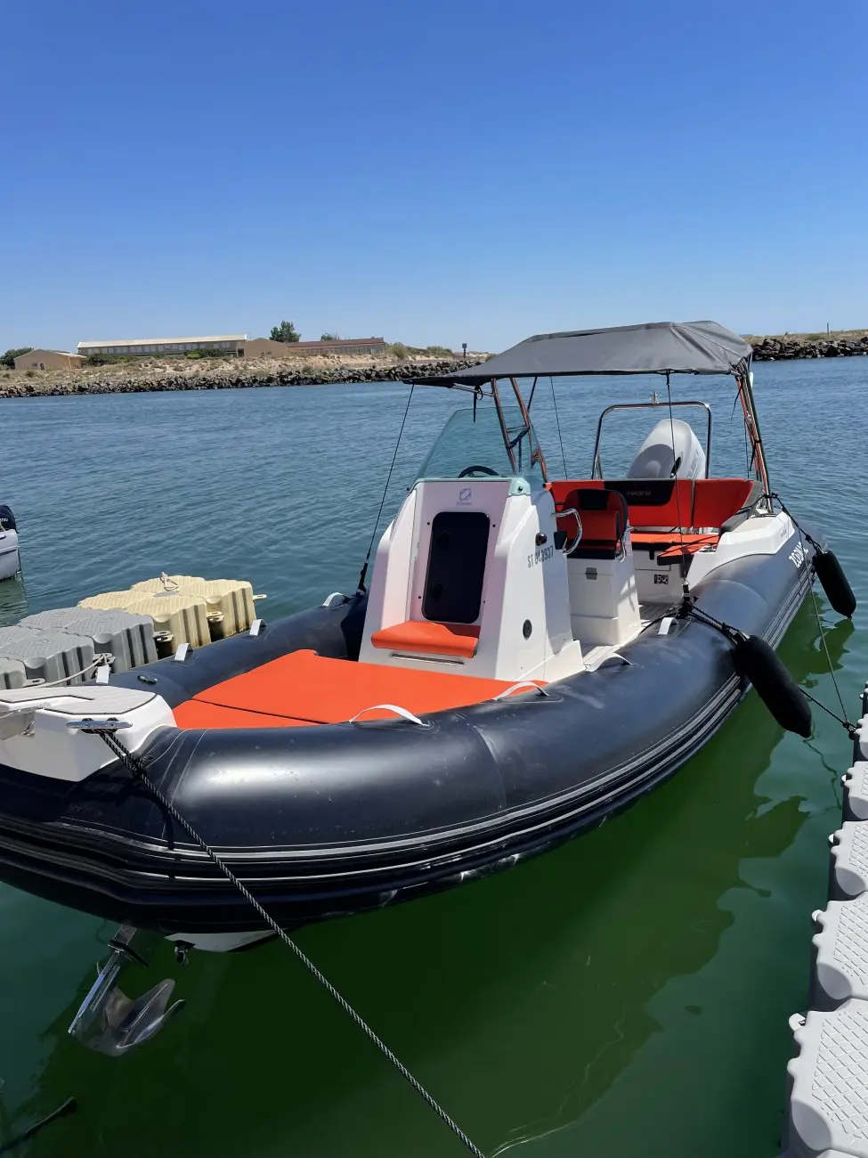 Zodiac Medline 680 — Bateau pneumatique à console centrale amarré dans un port, vu de trois quarts arrière.