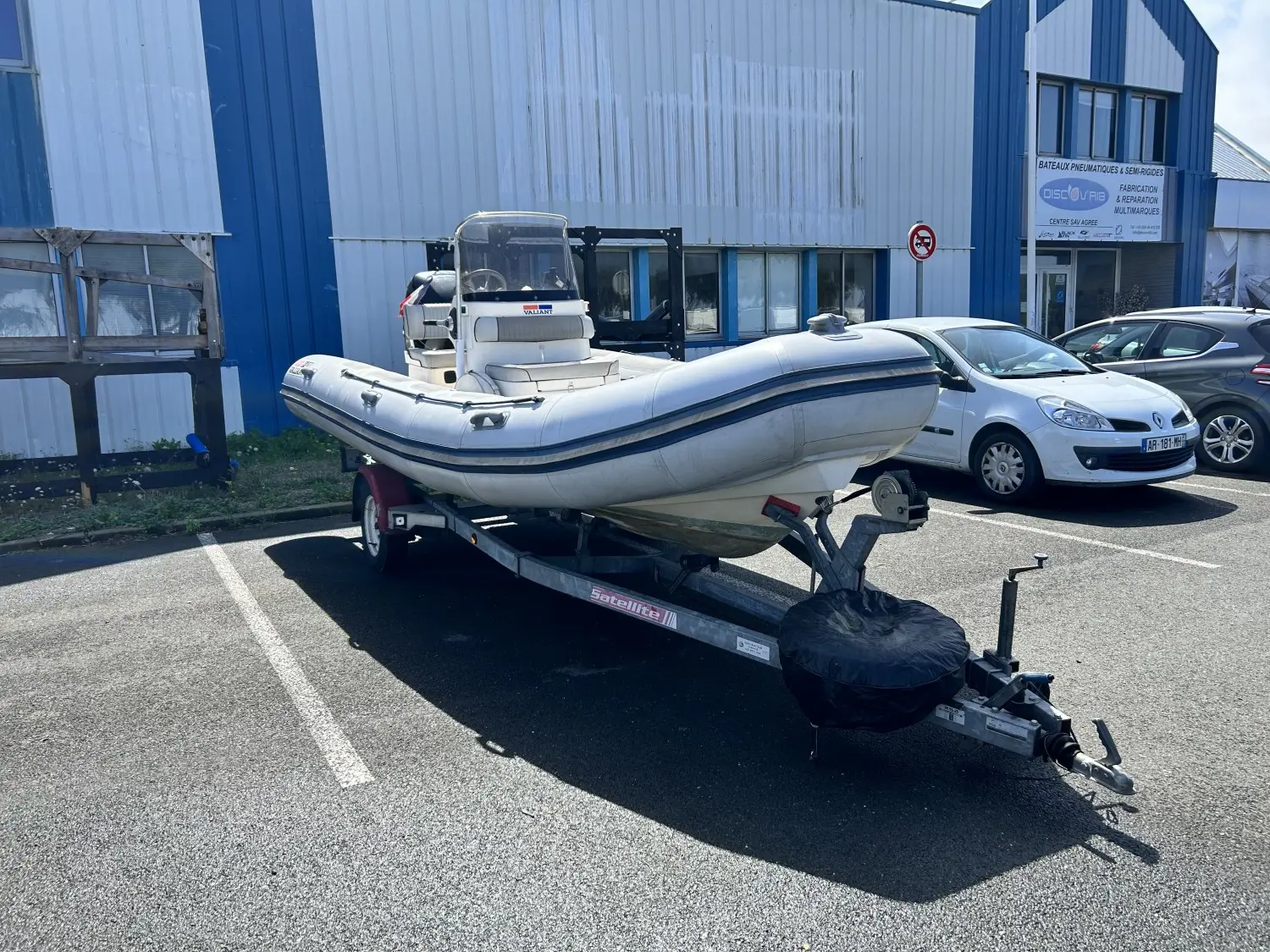 Valiant DR 570 — Bateau pneumatique blanc sur remorque, photographié en trois quarts devant un bâtiment.