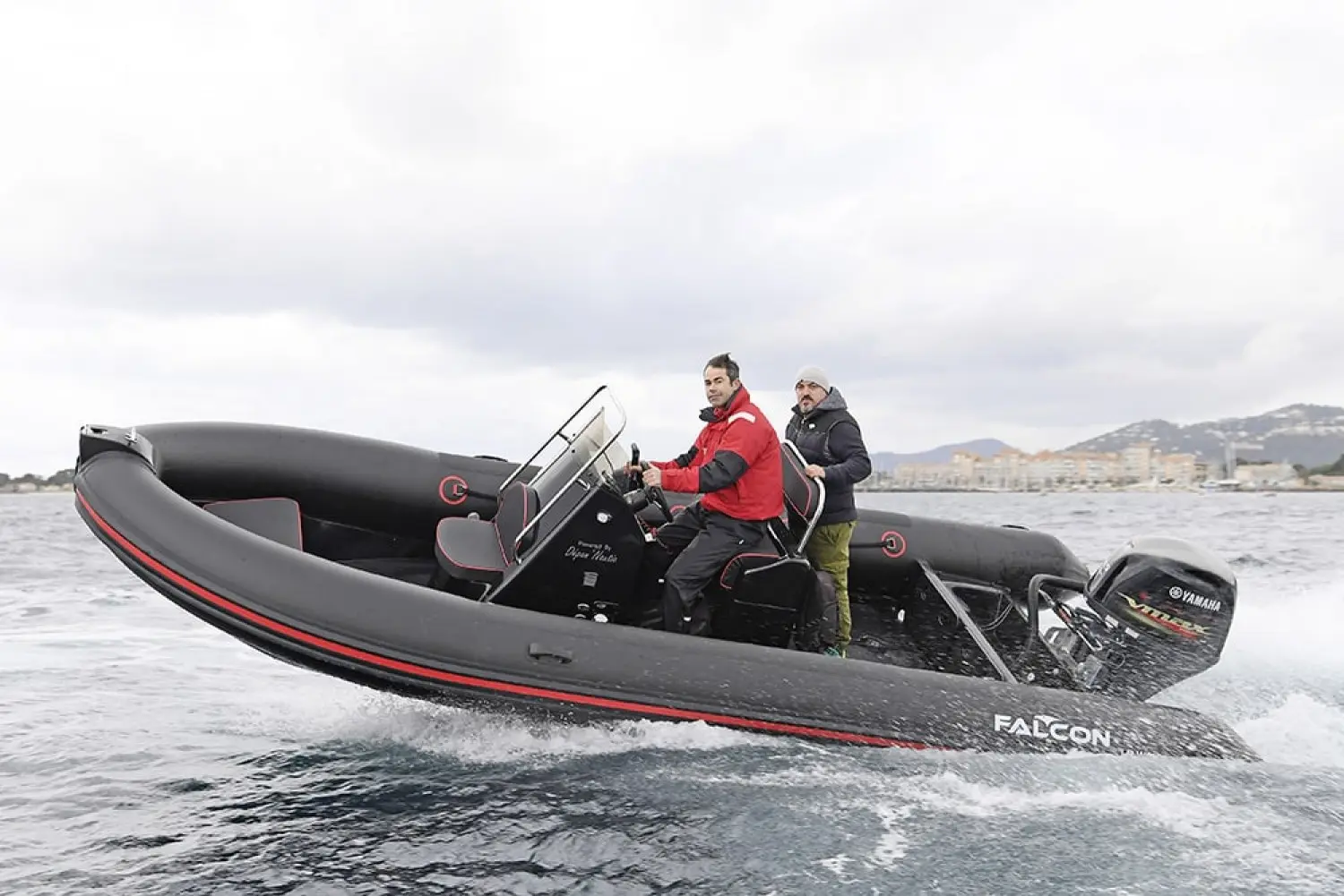 Falcon 575 — Semi-rigide noir et rouge naviguant avec deux personnes à bord.