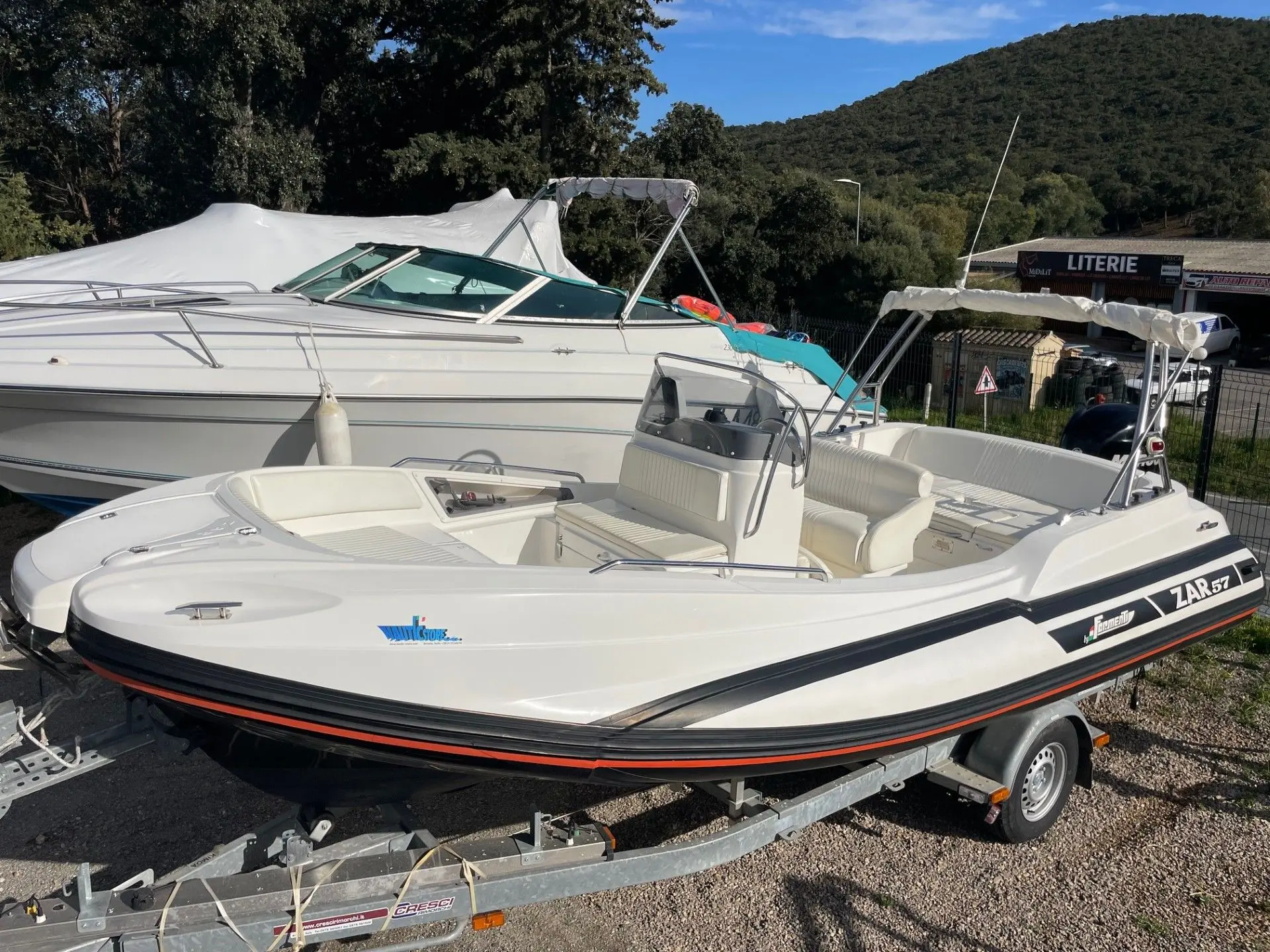 Zar Formenti Zar 57 Welldeck — Bateau pneumatique blanc sur remorque, photographié à terre en vue trois-quarts.