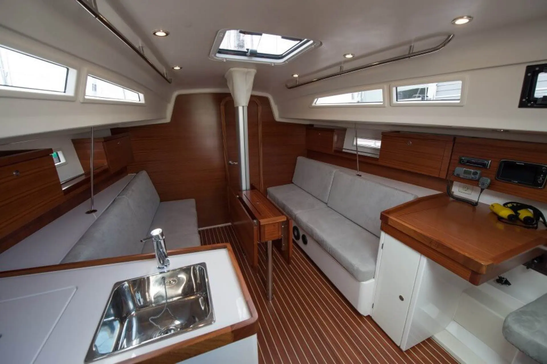Salona 35 — Vue intérieure du carré et de la cuisine avec banquettes, table et équipements de bord.