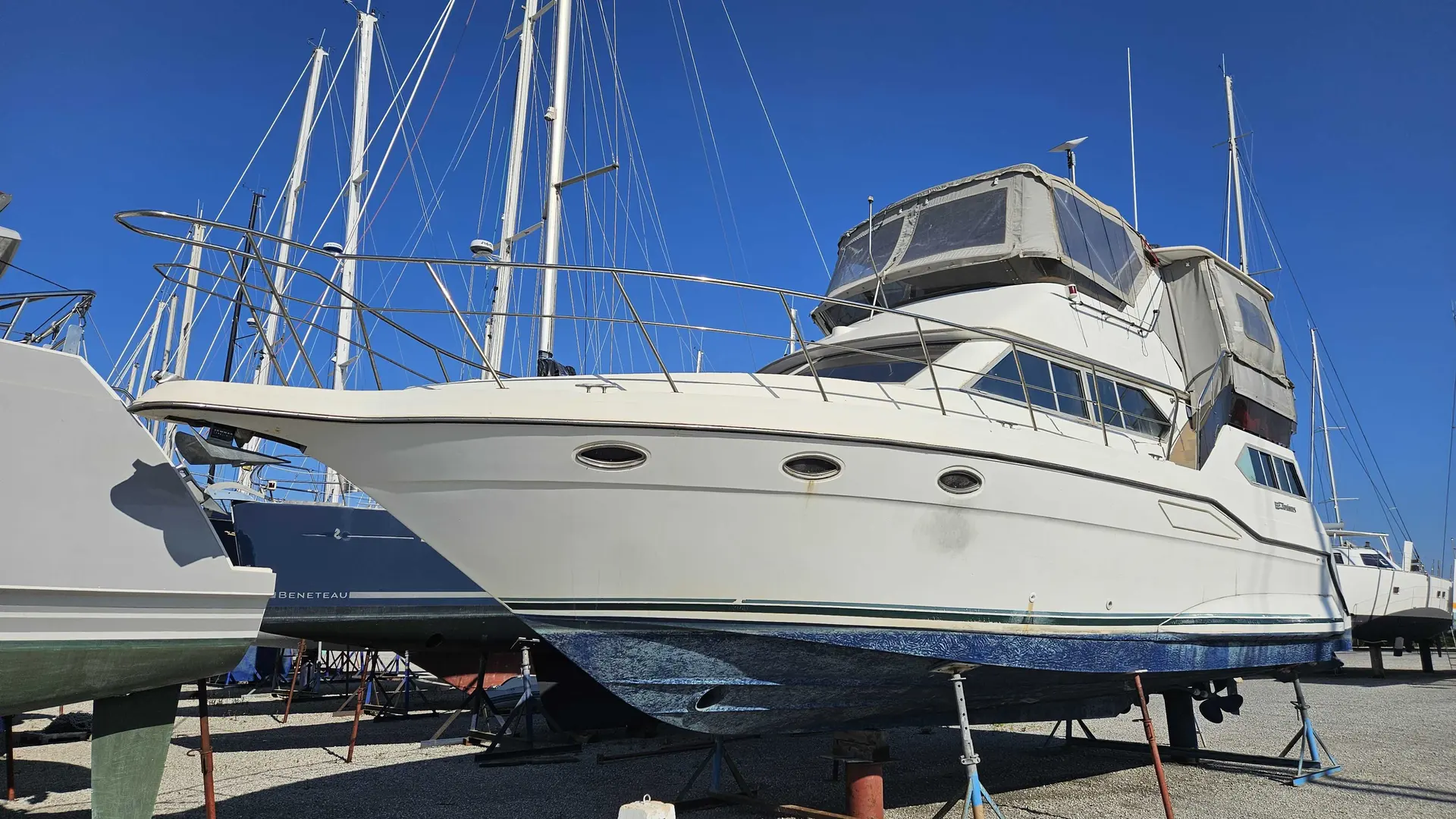 Cruisers Yachts 3850 AFT — Vedette à moteur blanche photographiée à terre dans un chantier naval.