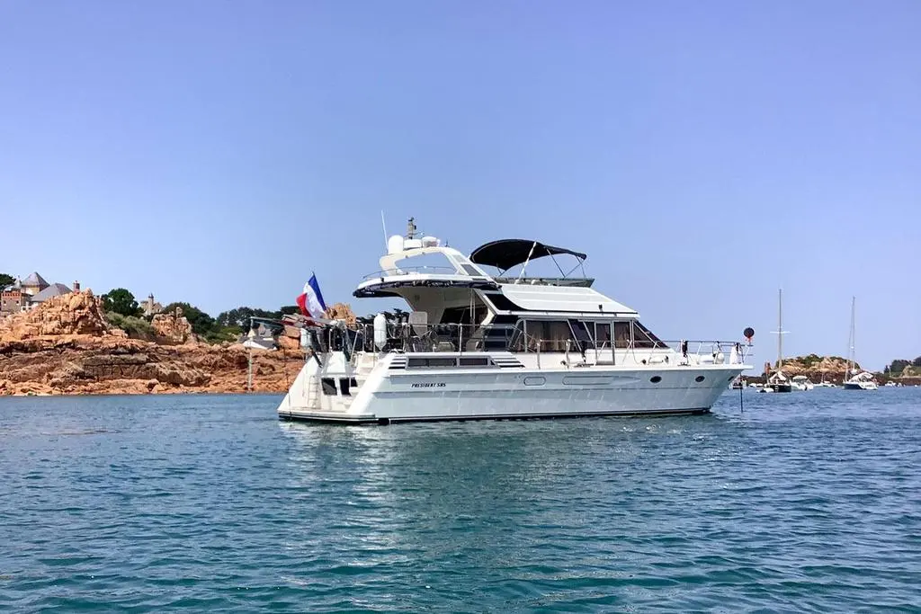 President 585 — Vedette à moteur blanche photographiée de profil sur une mer calme.