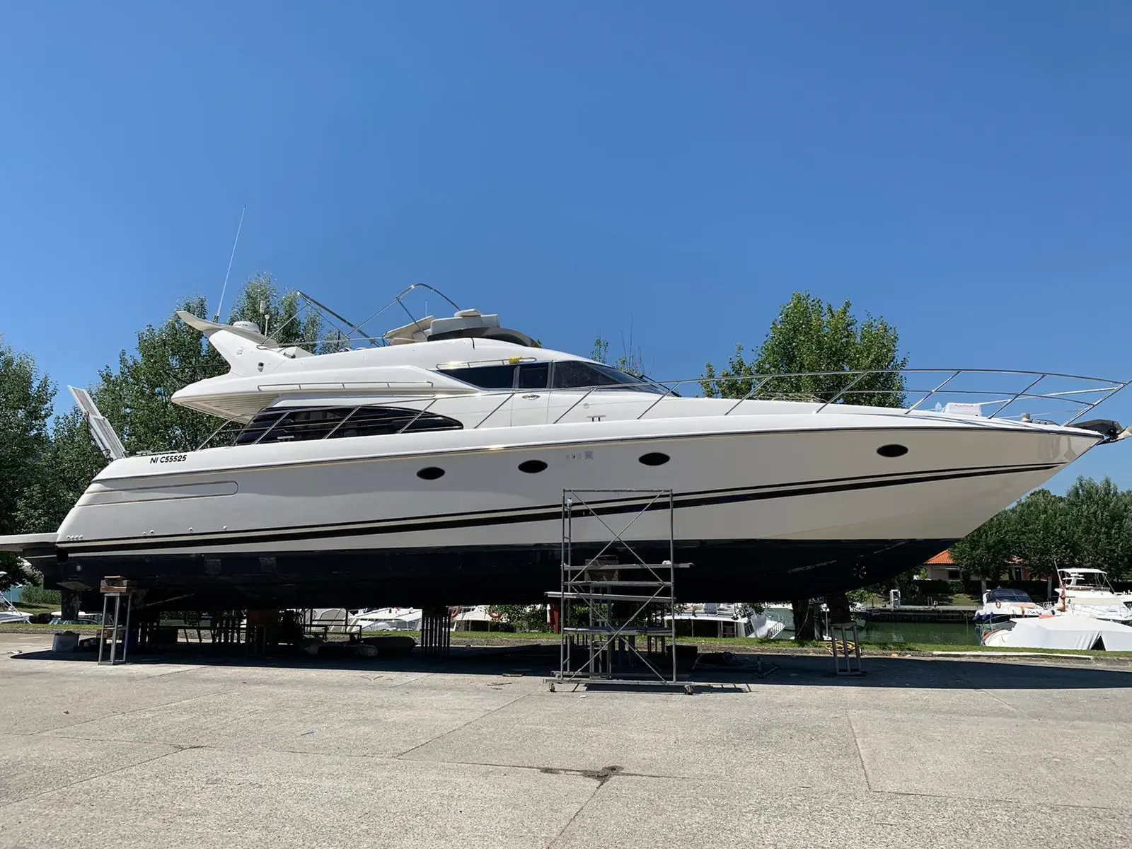 Sunseeker Manhattan 62 — Vue de profil d’un yacht à moteur blanc posé sur bers dans un chantier naval.