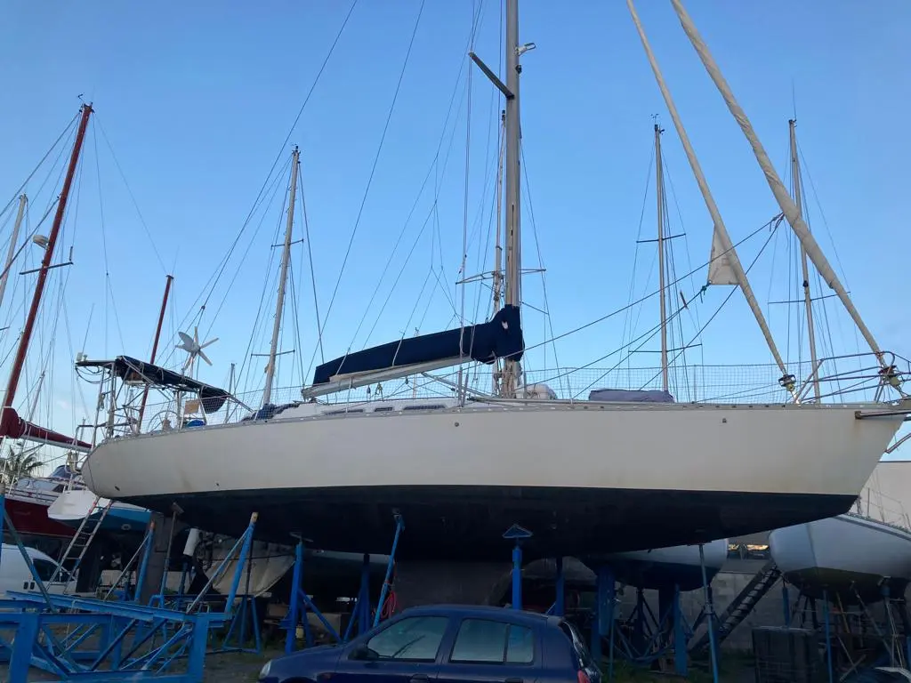 Atlantic 49 — Voilier blanc gréé, photographié à terre sur bers dans un chantier naval.