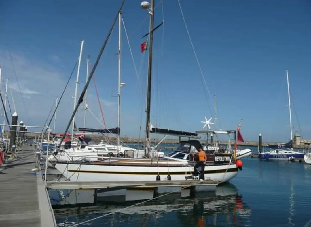 Comar Yachts Comet 11 — Voilier blanc amarré dans un port, photographié de profil par temps clair.