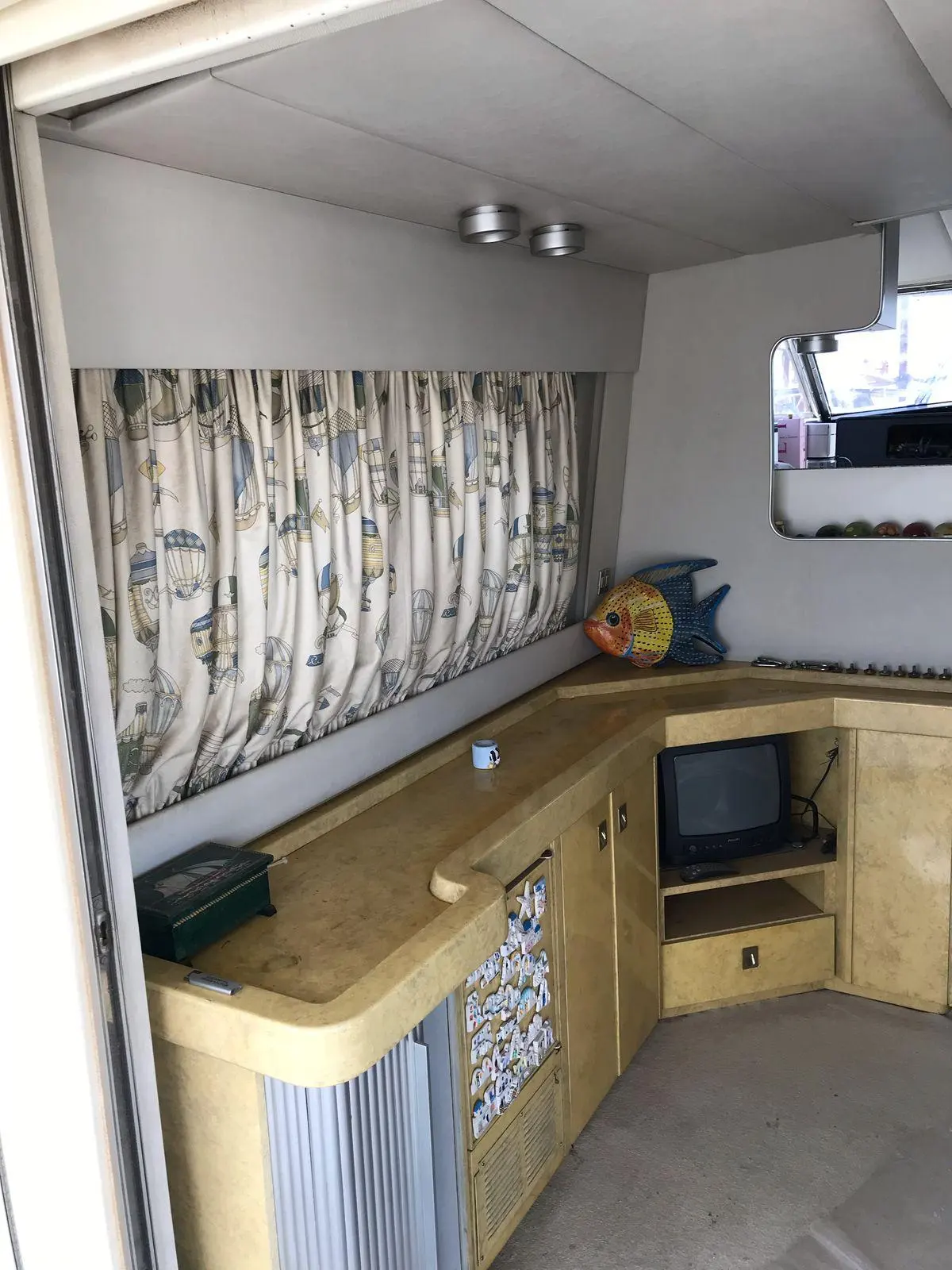 Gallart 1350 — Vue intérieure avec comptoir, rangements, rideaux et téléviseur.