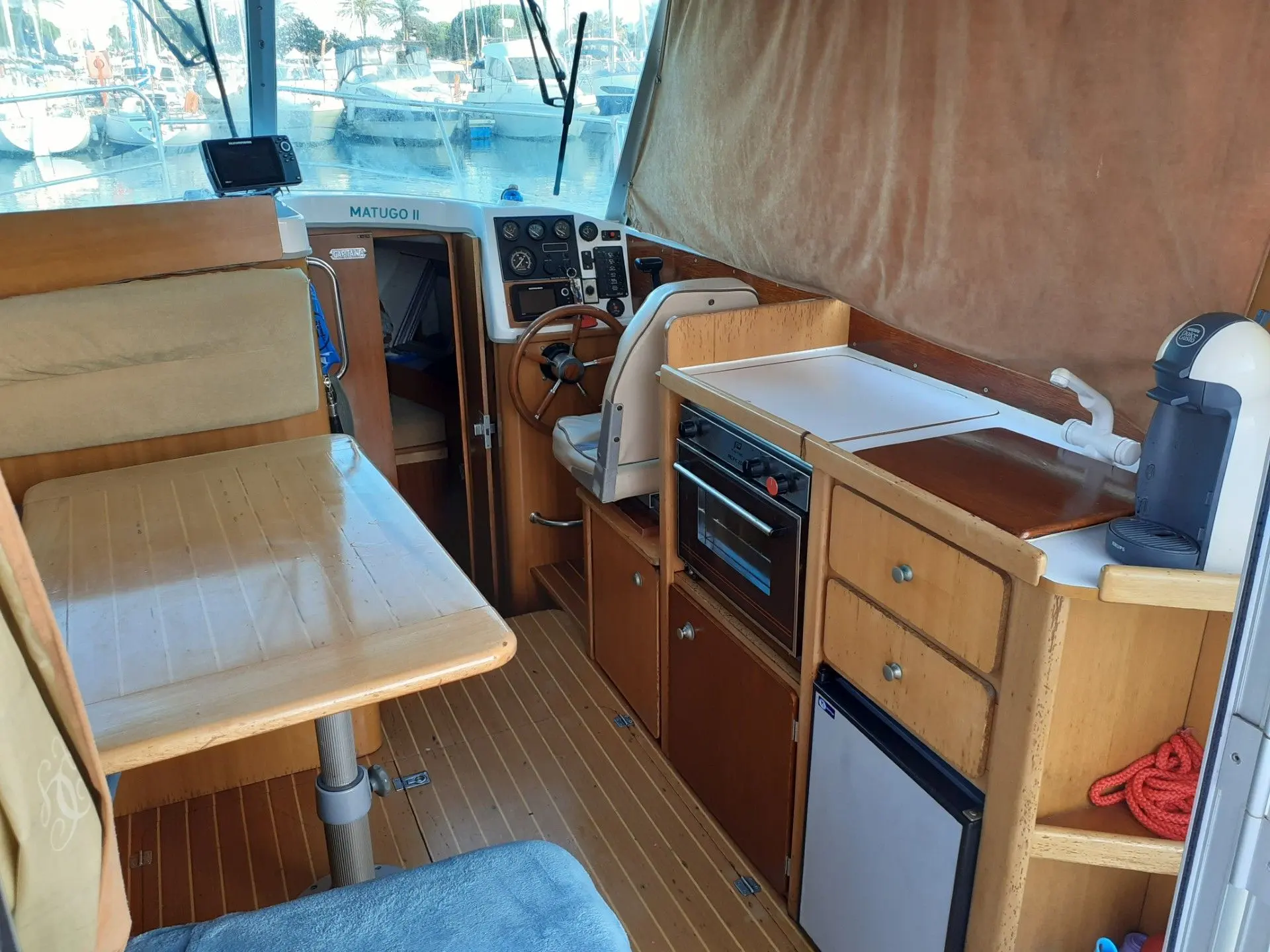 Ocqueteau 760 — Vue intérieure montrant le poste de pilotage et la cuisine du bateau.