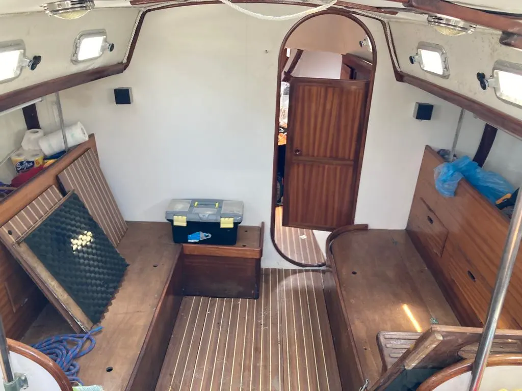 Olympic Carter 33 — Vue de l'intérieur en bois, avec banquettes, rangements et porte de cabine.