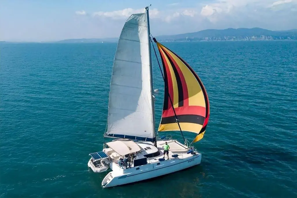 Fountaine Pajot Tobago 35 — Catamaran à voiles photographié en mer, sous grand-voile et spinnaker coloré.