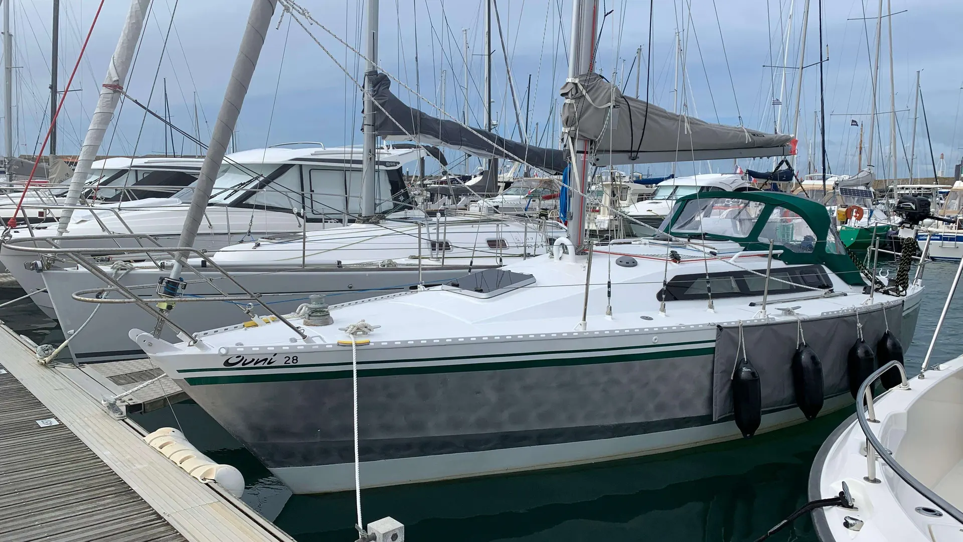 Alubat Ovni 28 — Voilier blanc amarré dans un port, vu de trois quarts bâbord.