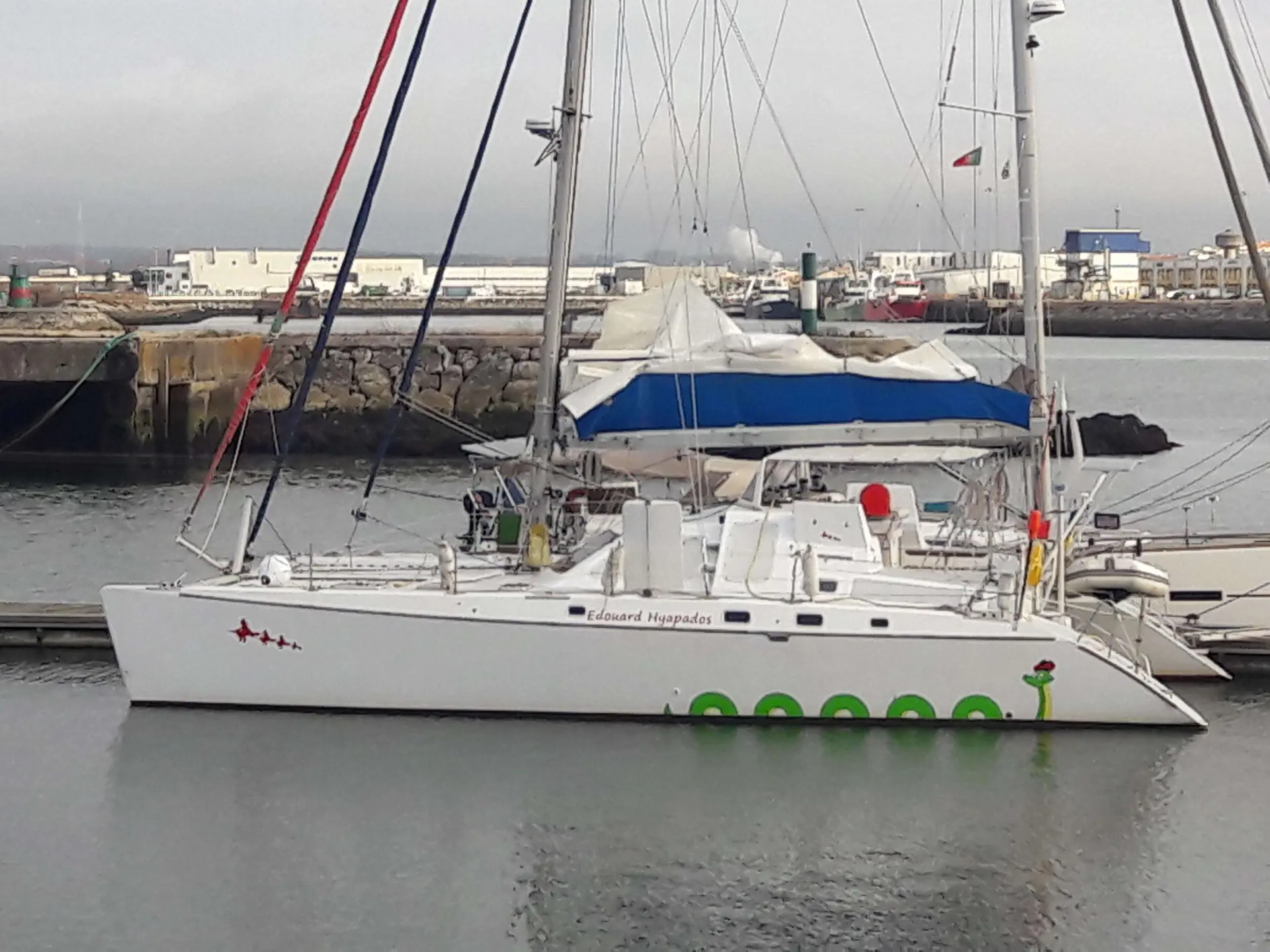 Custom Vplp 48 — Voilier blanc amarré dans un port, photographié de profil par temps couvert.