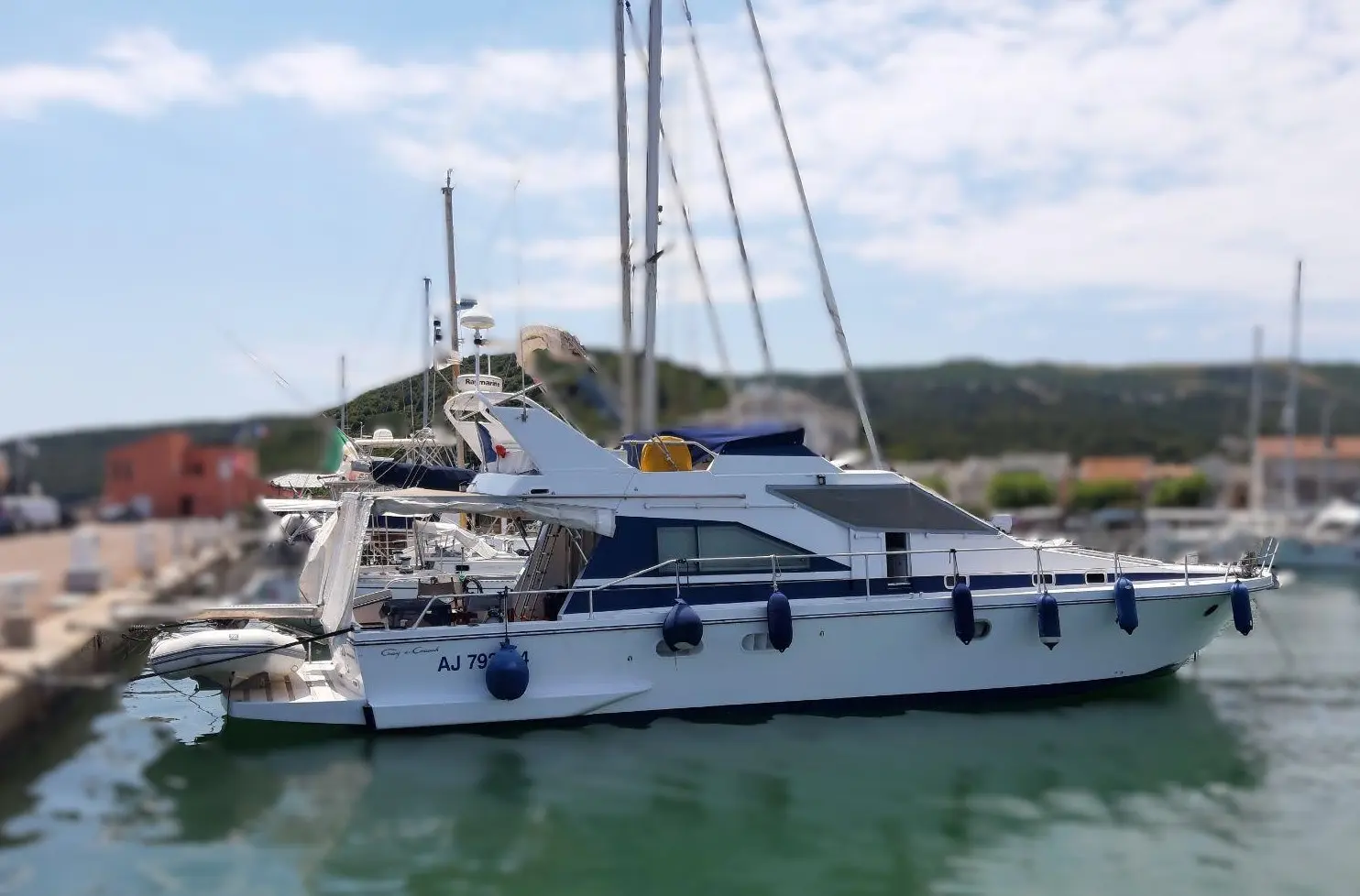 Guy Couach 1401 — Vedette blanche amarrée dans un port, vue de profil tribord.