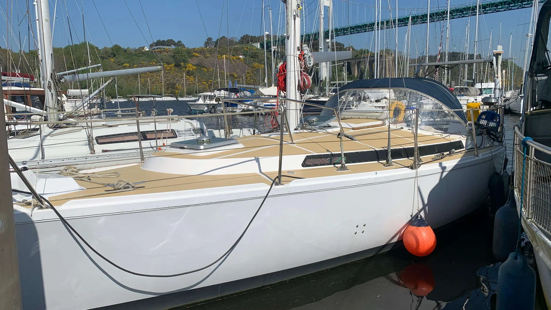 Jeanneau Gin Fizz — Voilier blanc amarré dans une marina, photographié par tribord sous un pont.