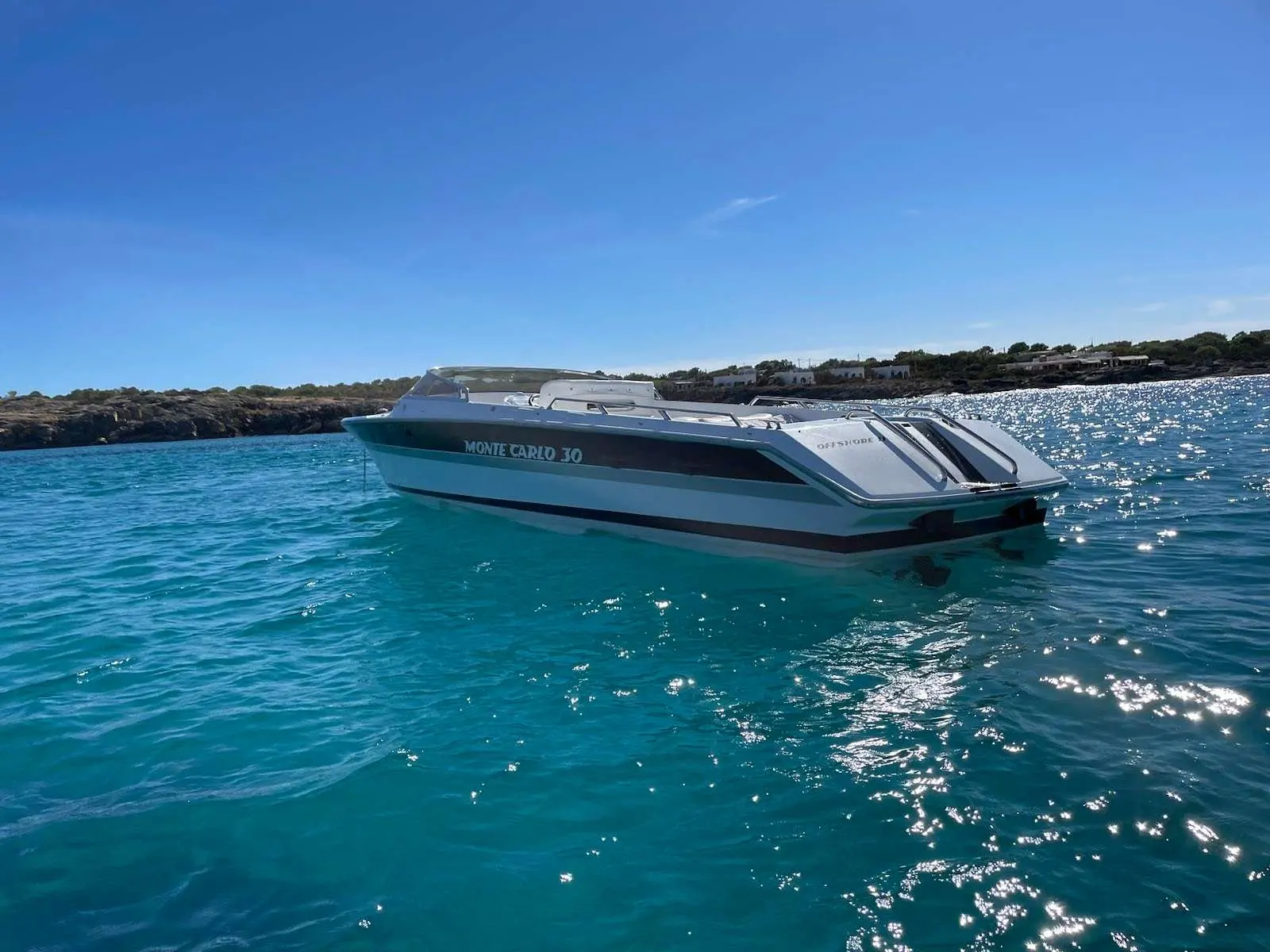 Monte Carlo Offshorer 30 — Bateau à moteur vu de trois quarts sur une mer turquoise.