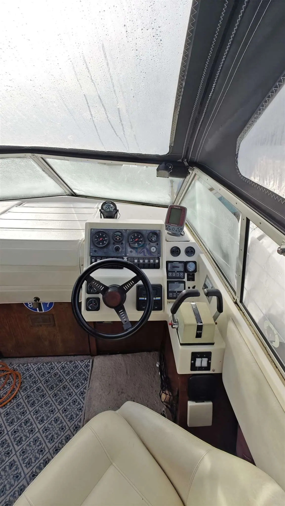 Fjord 725 — Vue du poste de pilotage avec volant, instruments et commandes moteur.
