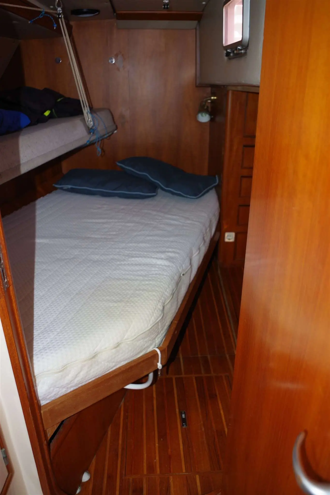 Hylas Yachts Hylas 51 — Cabine intérieure avec couchette double, coussins et rangements en bois.