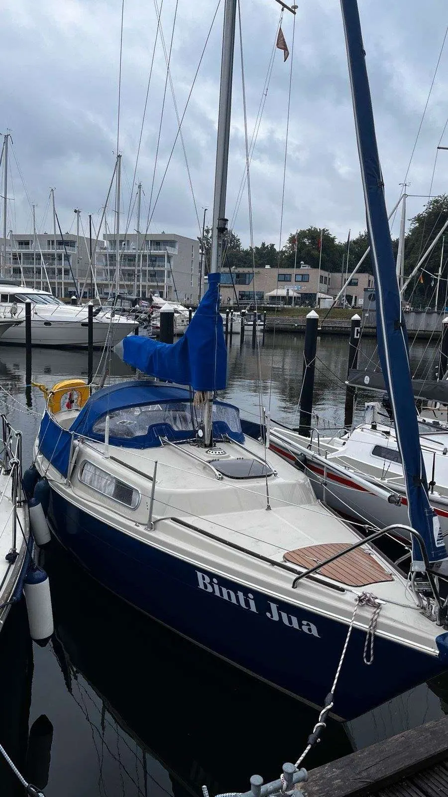 Dehler Delanta 76 — Voilier bleu et blanc amarré dans un port, vu de trois quarts avant.