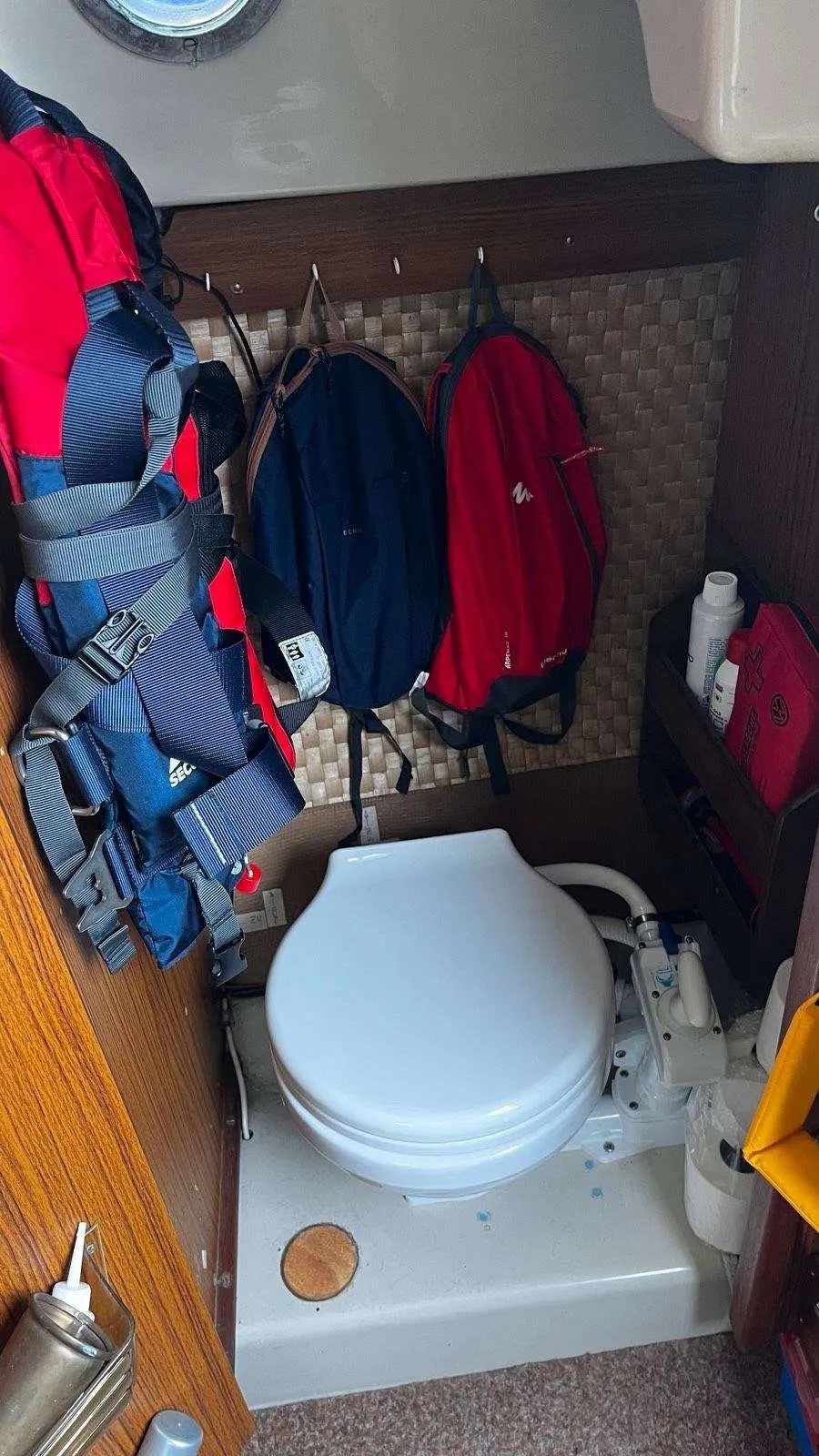 Dehler Delanta 76 — Toilettes marines entourées de gilets et de sacs à bord.