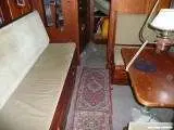 Vindo Marin Vindo 50 — Salon intérieur avec banquette claire, table en bois et passage central.